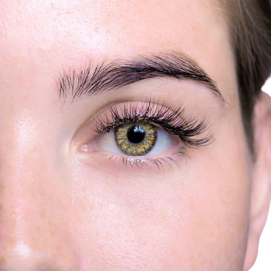 Close-up of a person's eye with gold and grey contact lens on a white background