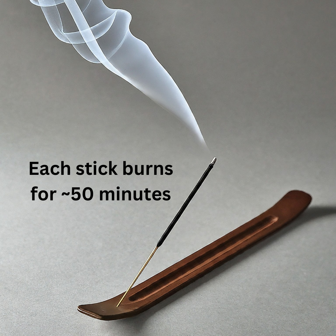 Incense stick with smoke rising from a wooden holder on a gray background