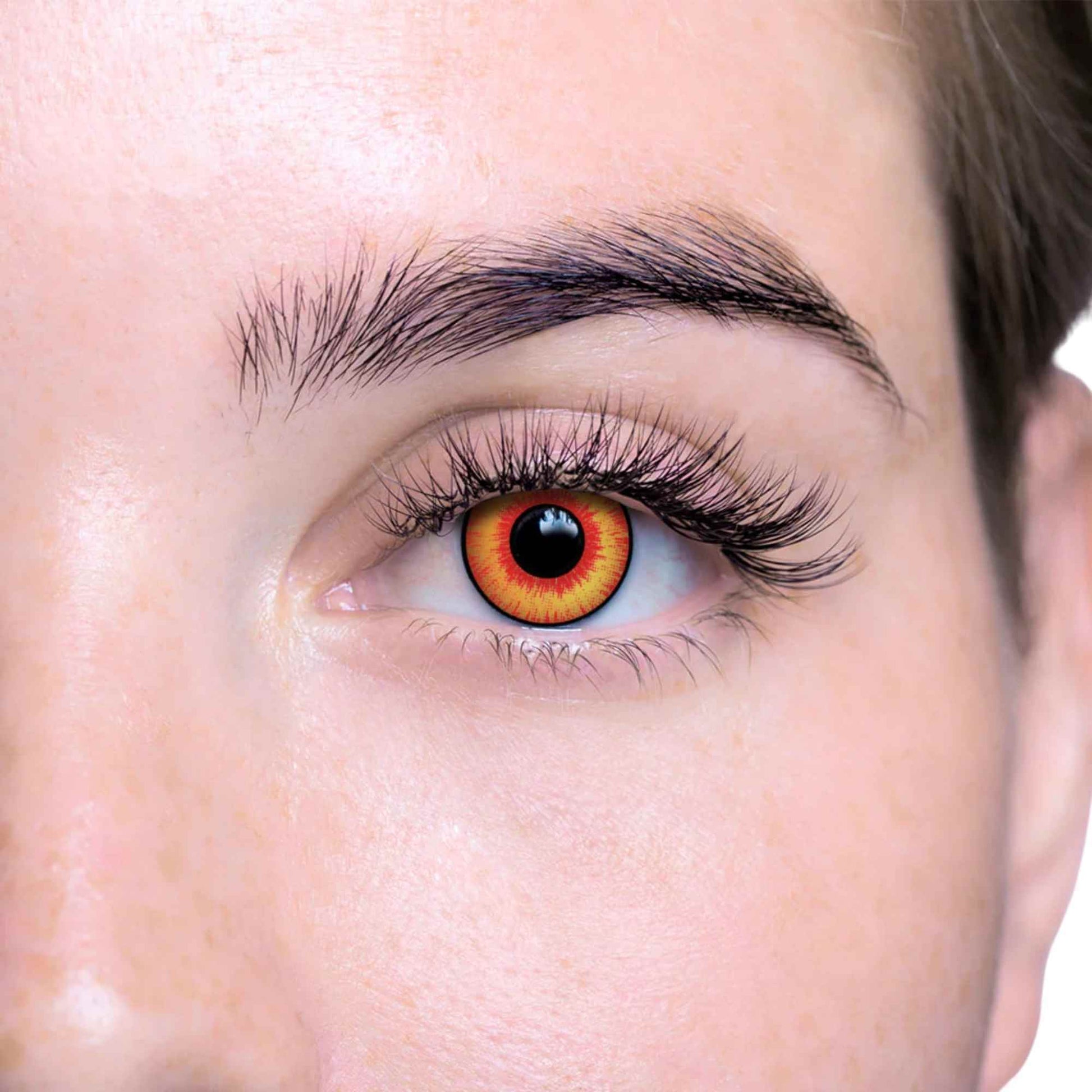 Close-up of a person's eye with multicolored contact lenses on a white background